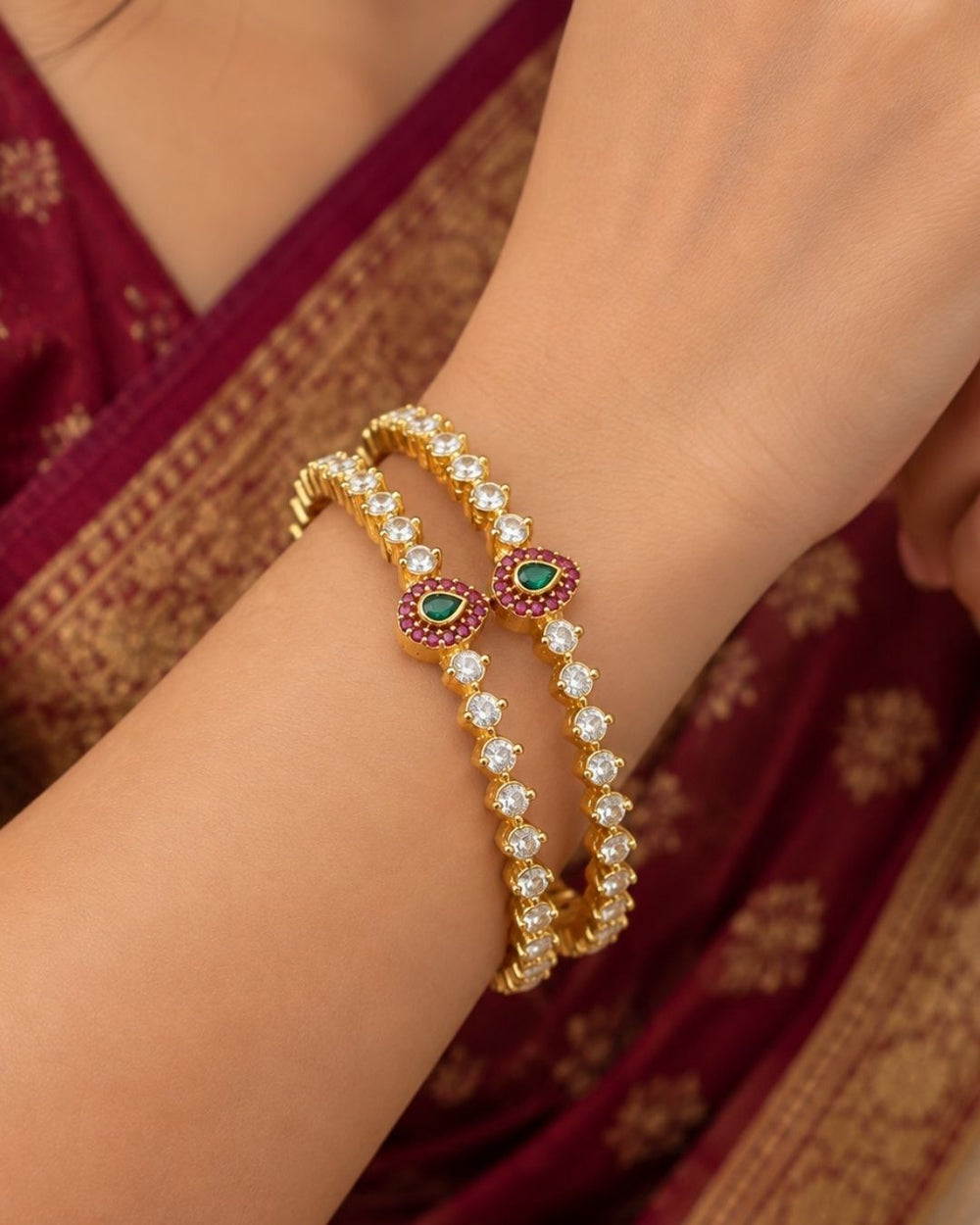 Elegant Jadau Kundan gold plated bangles featuring sparkling kundan stones with emerald teardrop accents. Perfect for weddings and festive occasions.