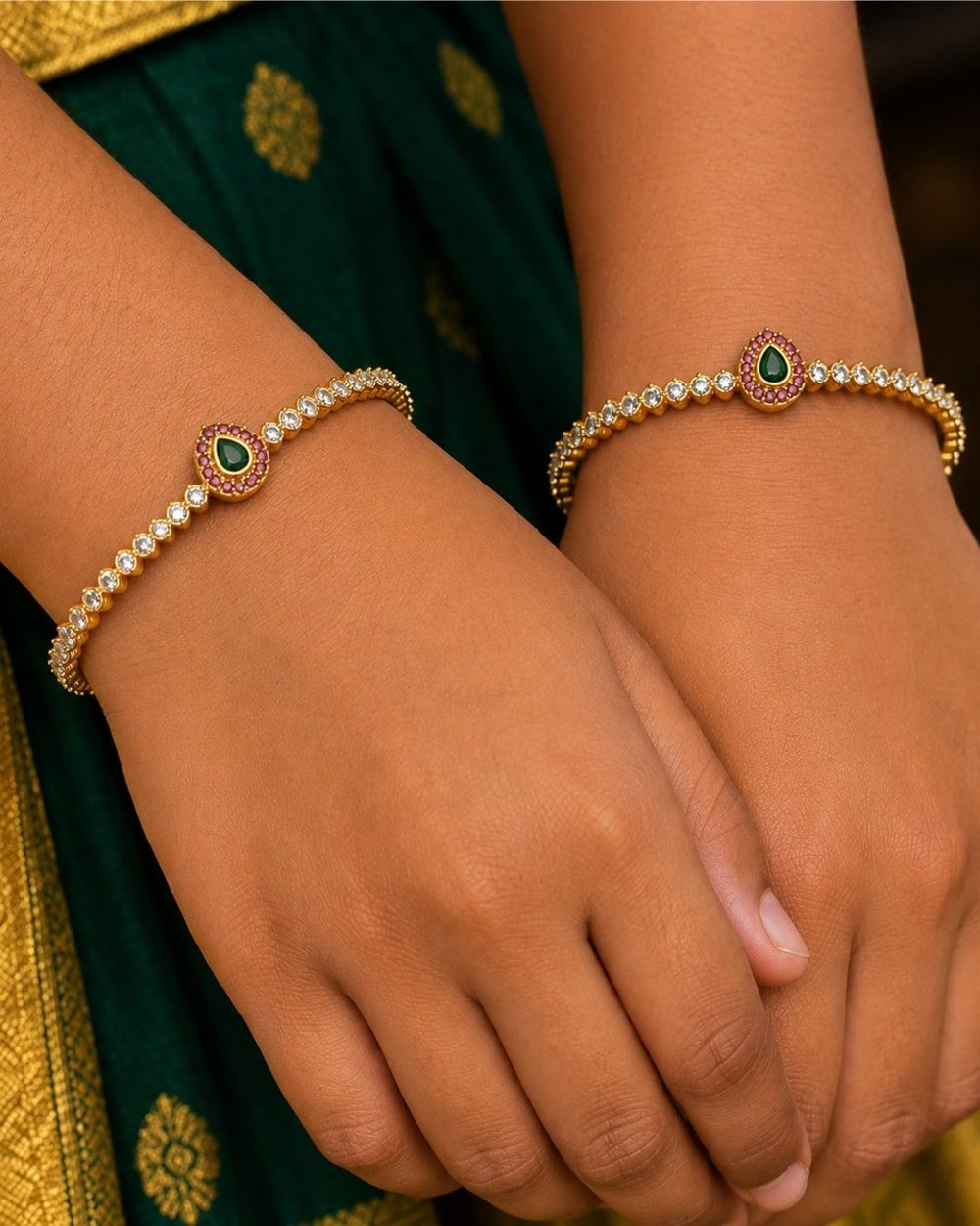 Elegant Jadau Kundan gold plated bangles featuring sparkling kundan stones with emerald teardrop accents. Perfect for weddings and festive occasions.