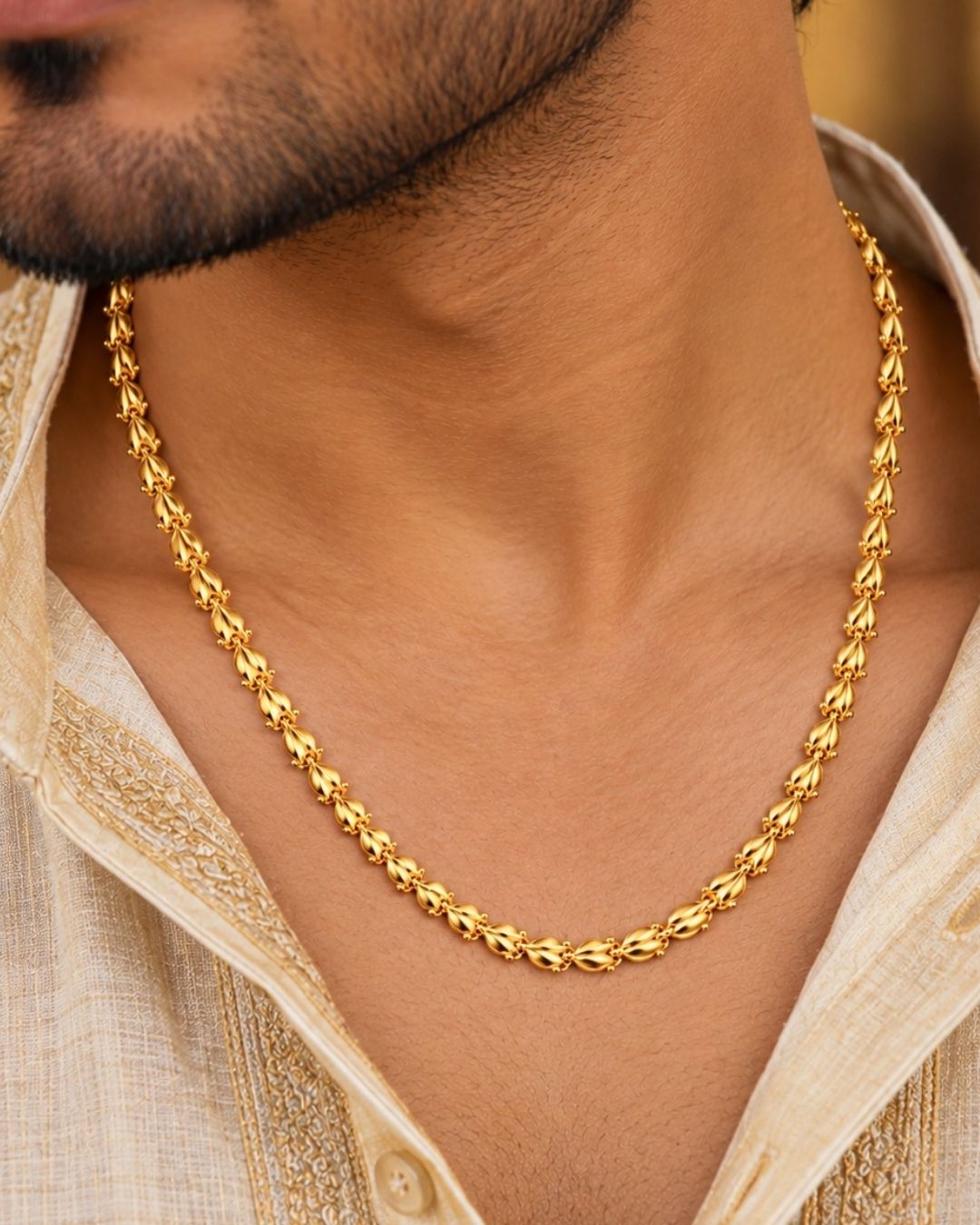 Gold plated men’s chain displayed in hand, showcasing its decorative leaf-shaped links and shiny finish.
