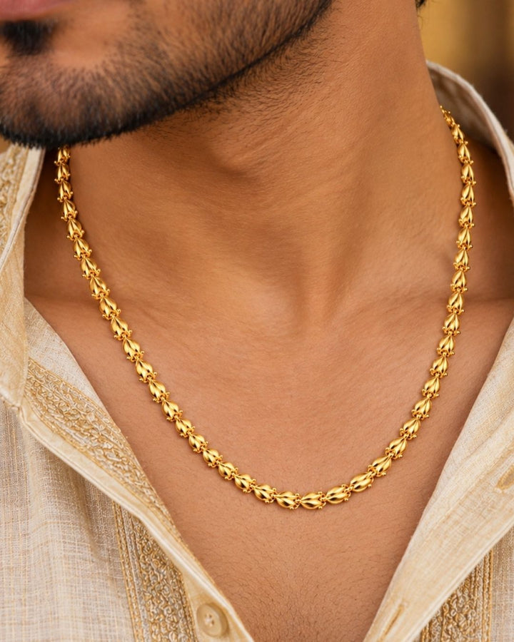 Gold plated men’s chain displayed in hand, showcasing its decorative leaf-shaped links and shiny finish.