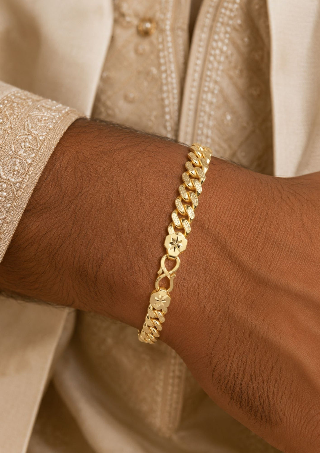 A close-up of a gold chain bracelet worn on a person&