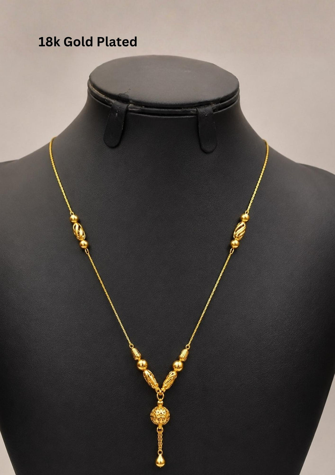 Elegant 18K gold plated necklace featuring textured designer beads and a beautifully crafted spherical drop pendant with a delicate dangling charm. Lightweight and ideal for everyday elegance.