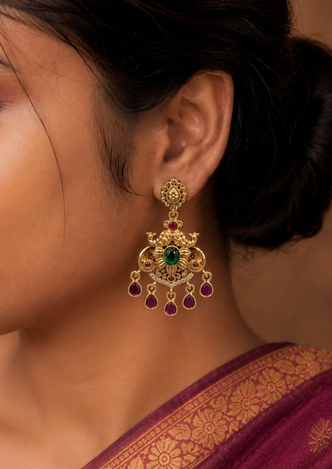 Close-up of a South indian women ear wearing a pair of sleek gold bangles with a clean, modern design. The pattern alternates between plain shiny gold blocks and blocks filled with sparkling white crystals.