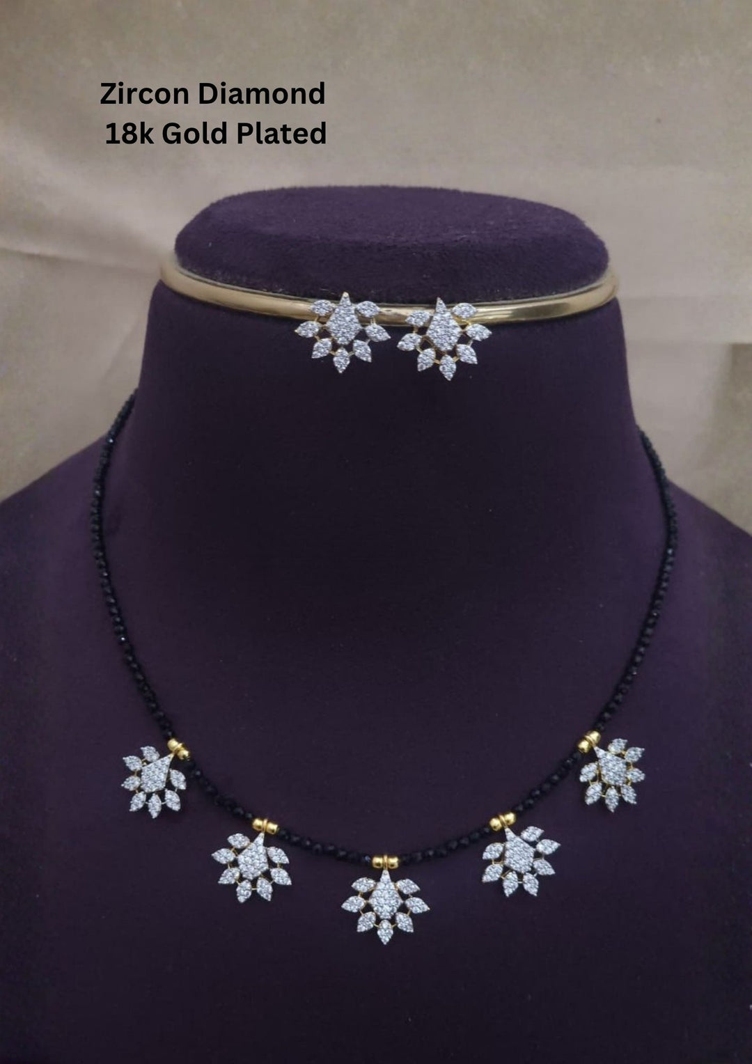 Modern Zircon Diamond gold plated mangalsutra necklace The design features a delicate gold link chain transitioning into sections of traditional small black beads on both sides. The central pendant showcases a sleek, contemporary curved Tear drop pendant with sparkling white cubic zirconia stones. This elegant neckpiece perfect for daily wear, office wear, and casual outfits.