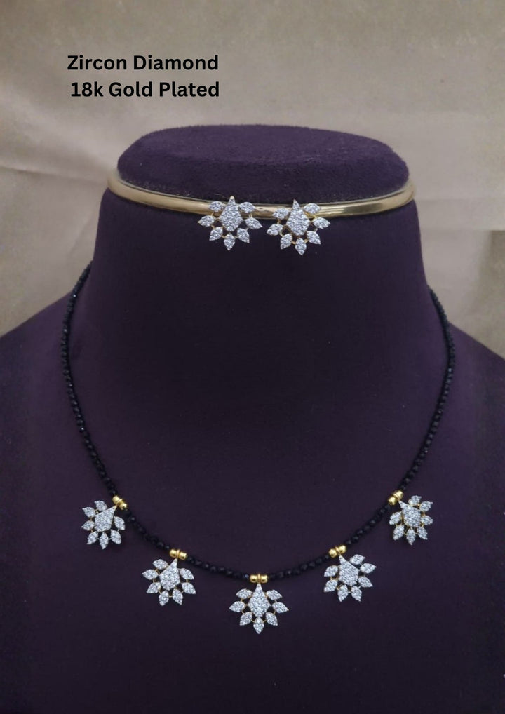 Modern Zircon Diamond gold plated mangalsutra necklace The design features a delicate gold link chain transitioning into sections of traditional small black beads on both sides. The central pendant showcases a sleek, contemporary curved Tear drop pendant with sparkling white cubic zirconia stones. This elegant neckpiece perfect for daily wear, office wear, and casual outfits.