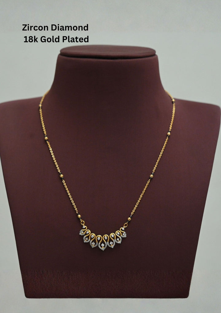Modern Zircon Diamond gold plated mangalsutra necklace The design features a delicate gold link chain transitioning into sections of traditional small black beads on both sides. The central pendant showcases a sleek, contemporary curved V-shape and a stylized butterfly or floral motif encrusted with sparkling white cubic zirconia stones. This elegant neckpiece perfect for daily wear, office wear, and casual outfits.