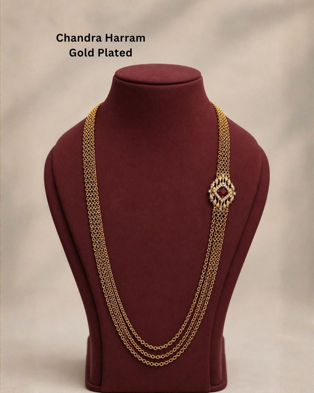 Beautiful ruby stone Chandra Haram gold plated necklace featuring multiple layered chains and an elegant red centerpiece with intricate gold and sparkling stone detailing. Perfect for festive occasions, traditional outfits, weddings, temple visits, and premium gifting.