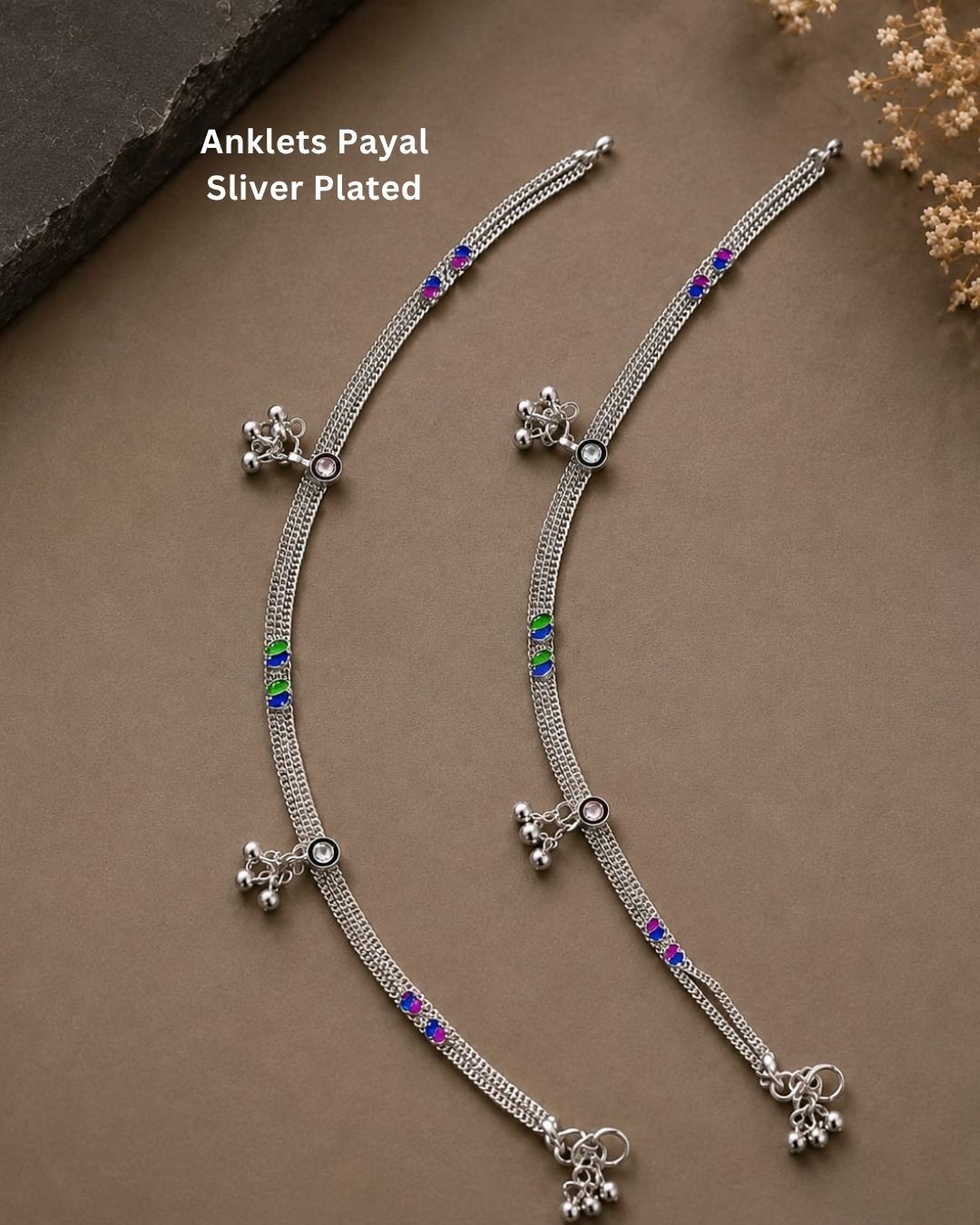 Beautiful silver plated multicolor anklet set featuring delicate layered chains, blue, pink, and green stone detailing, and dangling silver bead charms. Perfect for traditional occasions, festive wear, daily wear, and gifting.