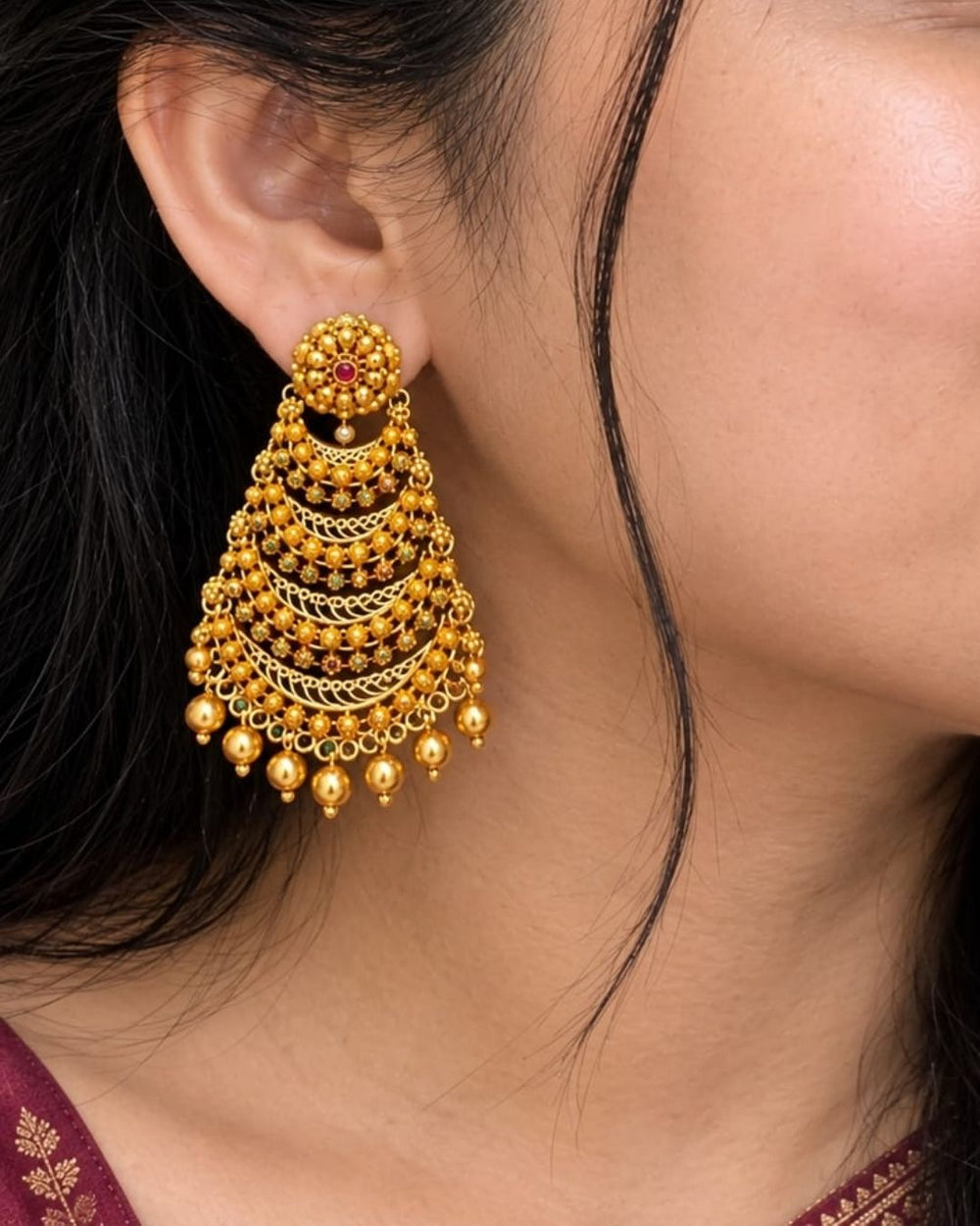 Premium gold plated traditional jhumka earrings featuring detailed floral motifs, multiple ornate layers, and delicate gold bead drops. Perfect for weddings, festive occasions, traditional wear, parties, and gifting.