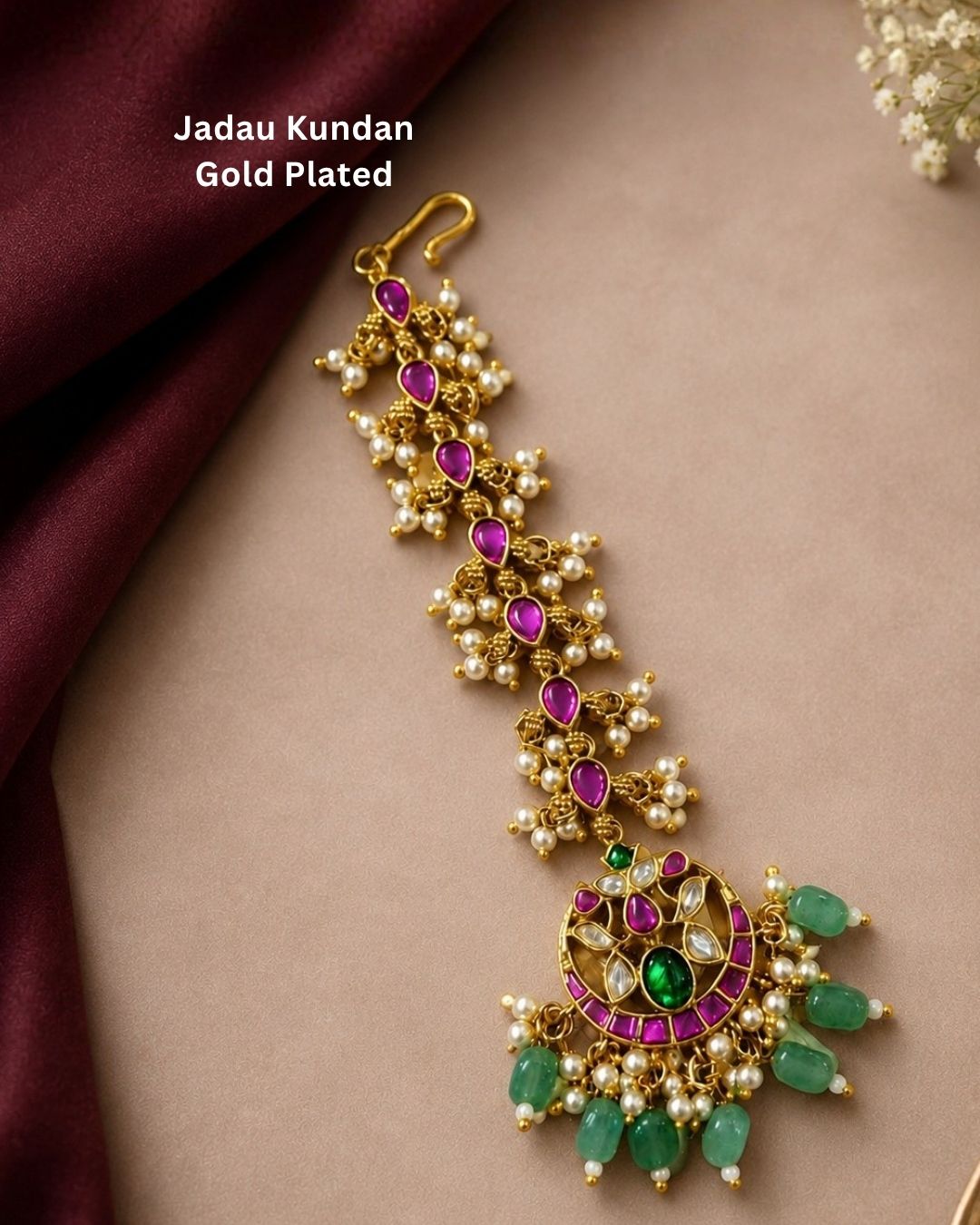 Beautiful traditional gold plated maang tikka featuring a long pink stone chain, a circular multicolor pendant with green and pink stones, and multiple pearl and green bead drops. Perfect for weddings, festive occasions, traditional outfits, bridal styling, and special celebrations.