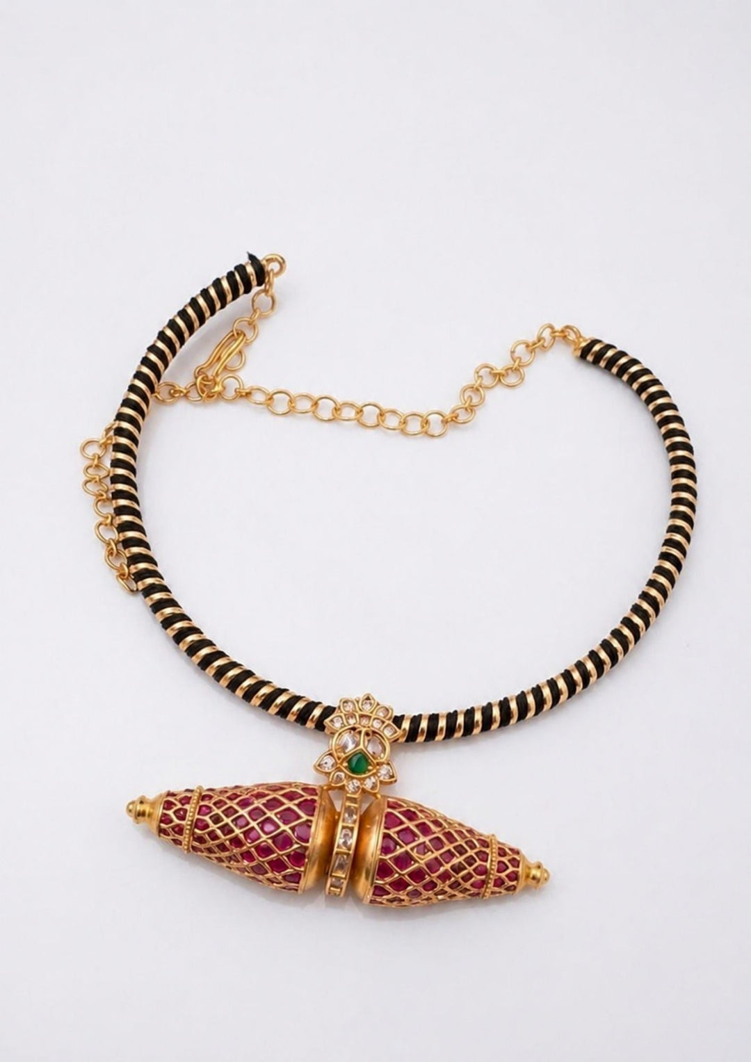 Necklace with black and gold chain and red and gold pendant on a white background