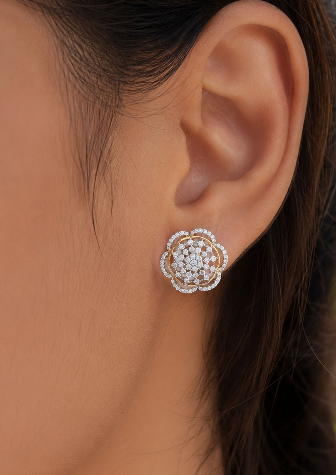 Close-up of an south indian women ear wearing gold-plated, multi-layered zircon diamond floral stud earrings. The intricate pavé setting creates a high-shine, luminous effect, making these versatile studs a perfect standalone accessory for both festive events and elegant cocktail parties.