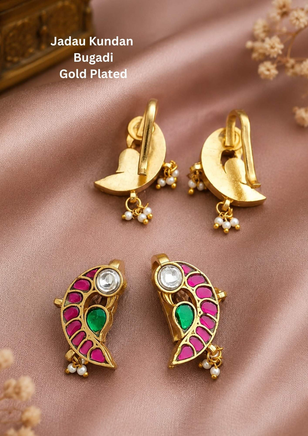 Gold-plated Jadau Kundan Bugadi earrings The earrings feature a crescent moon post with small pearl bead drops and fish-shaped studs decorated with pink and green enamel, a clear stone, and pearl bead accents. Beautiful paisley-inspired earrings featuring ruby, emerald, and kundan stones in a classic gold plated finish.
Finished with elegant pearl bead drops for a graceful traditional look.
Perfect for weddings, festive occasions, temple wear, and ethnic celebrations.