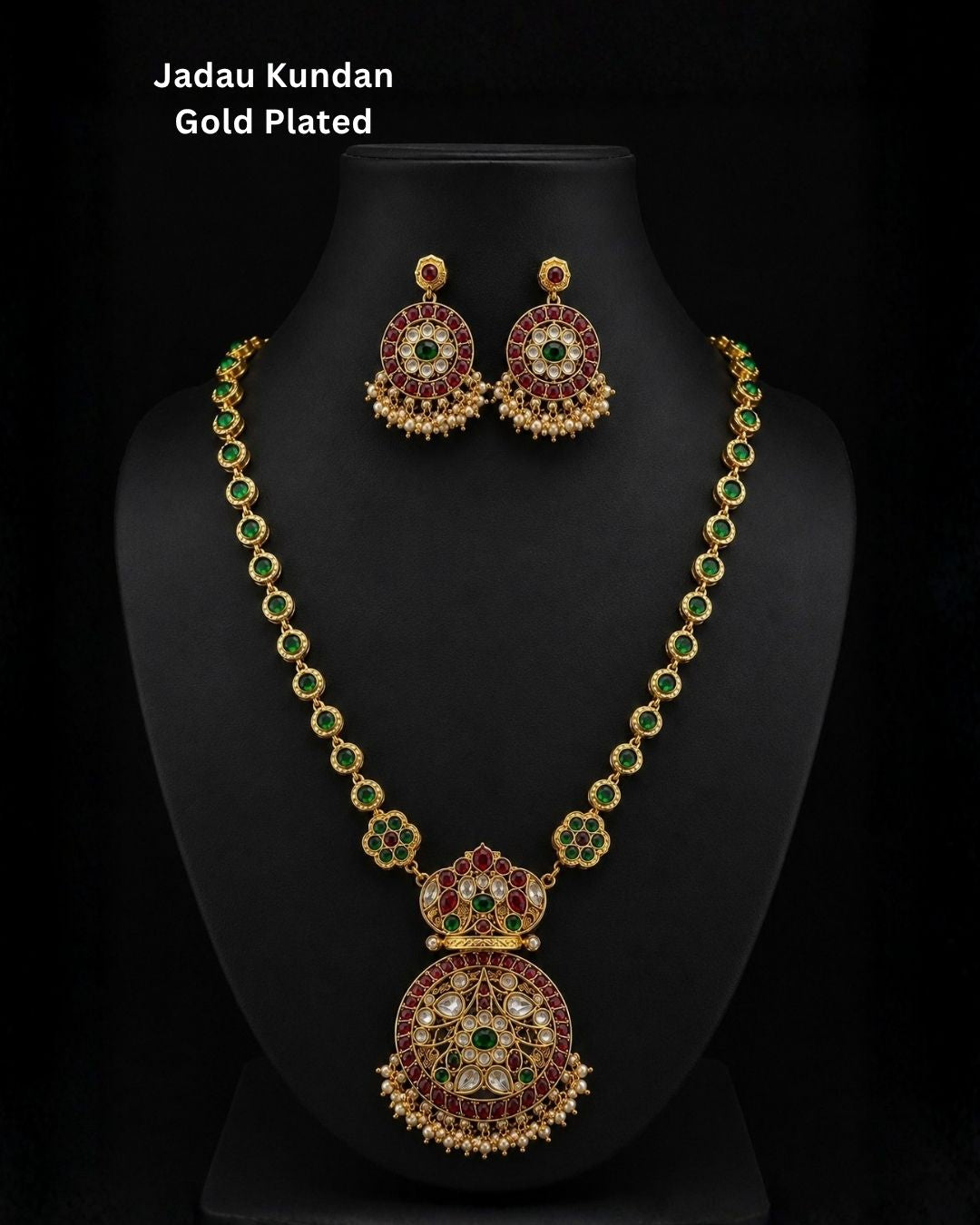 Premium gold plated CZ jewelry set with a ruby stone necklace, floral pendant, emerald green accents, pearl embellishments, and matching earrings for weddings and parties.