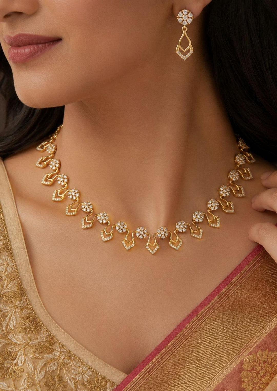 Modern south indian women wearing a, zircon diamond 18K gold-plated necklace and earring set showcasing delicate craftsmanship. The jewelry features sparkling diamond-like floral elements and curved drop shapes, making it a great choice to wear with sarees, lehengas, modern dresses, and festive wear for weddings, receptions, or family parties.