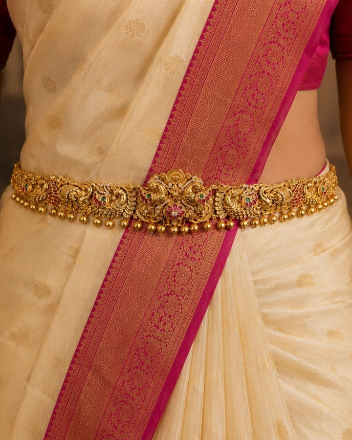 Beautiful temple-style gold plated hip belt featuring ornate peacock motifs, floral stone detailing, and hanging gold beads. Perfect for traditional sarees, festive occasions, weddings, Bharatanatyam performances, and special events.