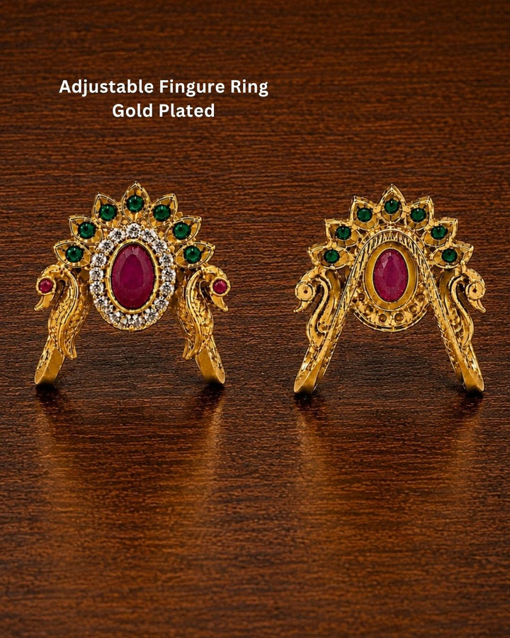 Beautiful peacock design gold plated ring featuring a prominent ruby-colored center stone, surrounding green stones, and sparkling accents. Perfect for festive occasions, traditional outfits, parties, and gifting.