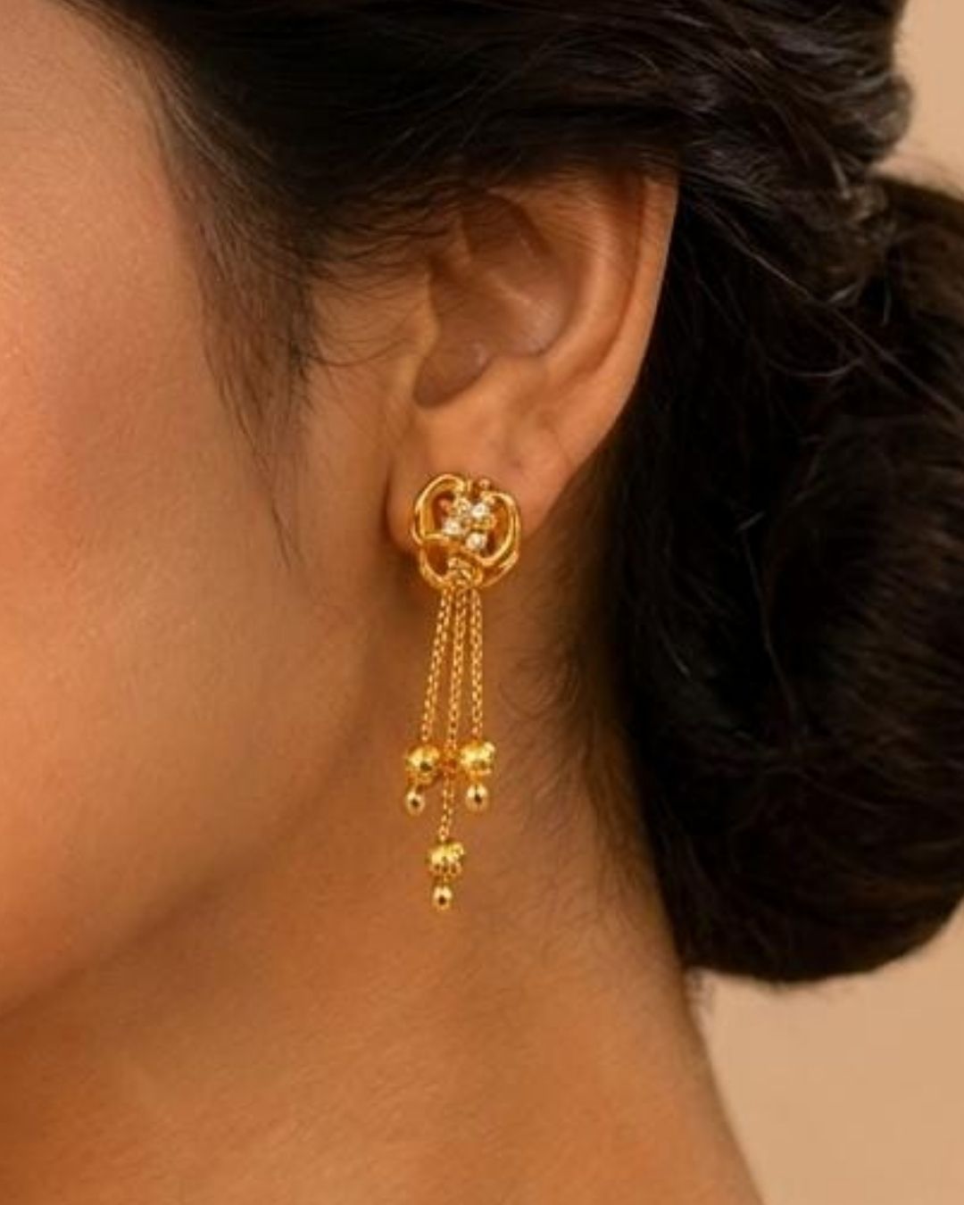 Stylish gold plated chain drop earrings featuring intricate curved detailing, sparkling white stones, multiple hanging chains, and polished gold ball accents. Perfect for festive occasions, traditional outfits, weddings, parties, and special events.