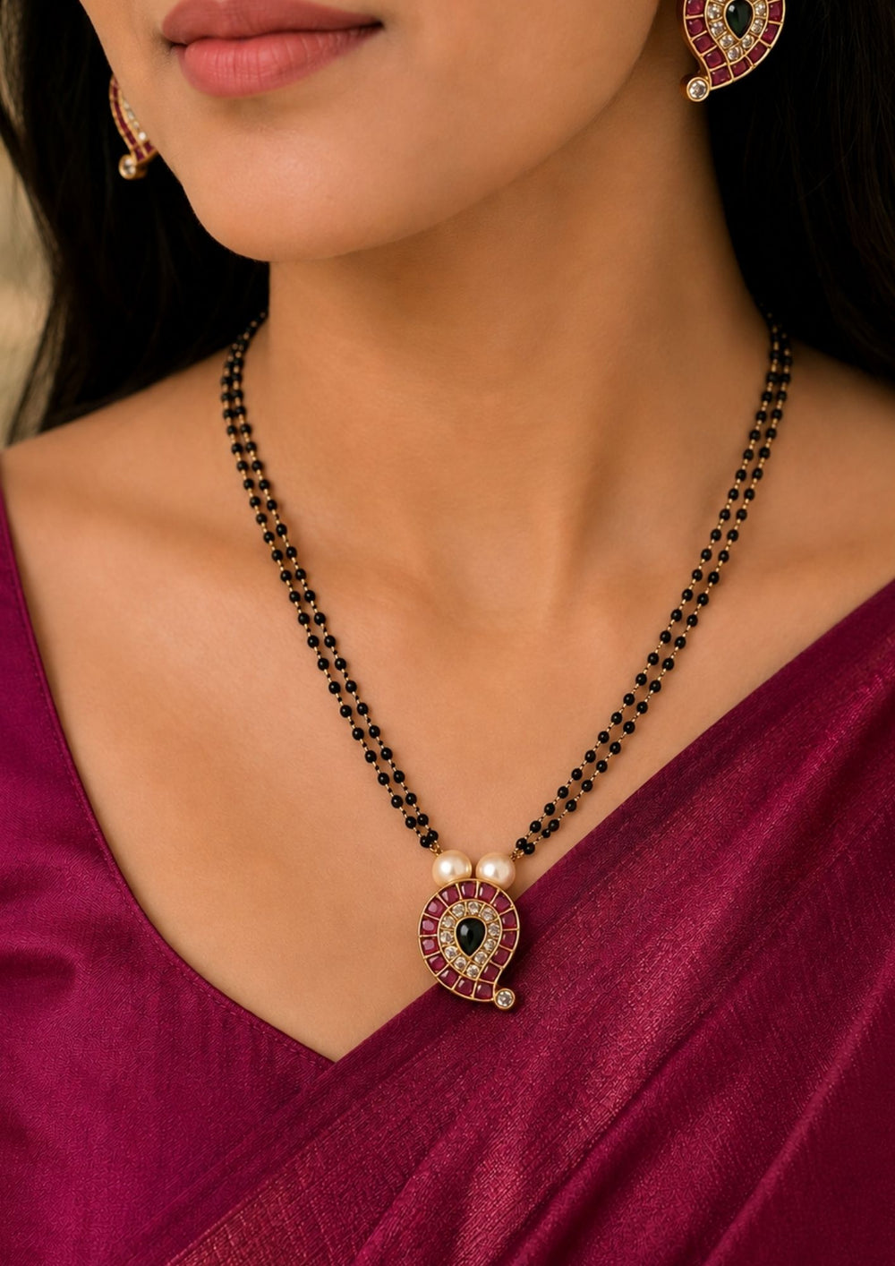South indian women's Traditional 18K gold plated double strand mangalsutra with a paisley-inspired kundan pendant, pearl detailing, and black beads, ideal for weddings, festive occasions, office wear, and daily styling.