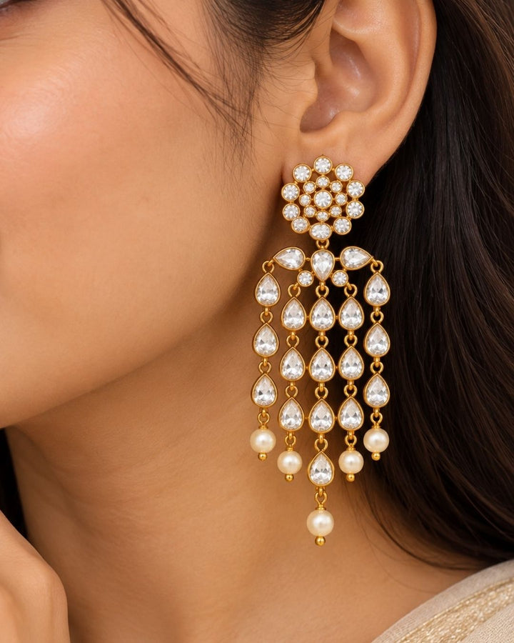  Close up offer south indian women wearing Beautiful zircon diamond gold plated chandelier earrings featuring dazzling pear-shaped zircon stones with graceful pearl drops. Perfect for weddings, receptions, parties, festive occasions, and premium gifting.