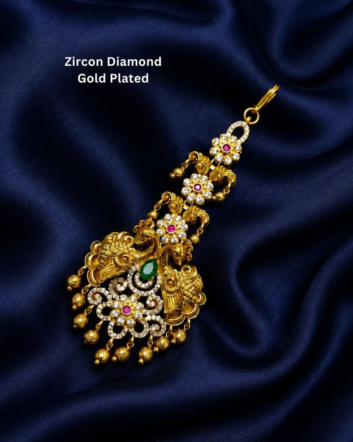 Beautiful traditional Peacock gold plated pendant featuring an intricately detailed Lord Peacock design, vibrant pink and green stones, ornate gold filigree, and clusters of white pearls with dangling gold beads around the lower edge. Perfect for festive occasions, temple visits, traditional outfits, weddings, spiritual gifting, and special celebrations.