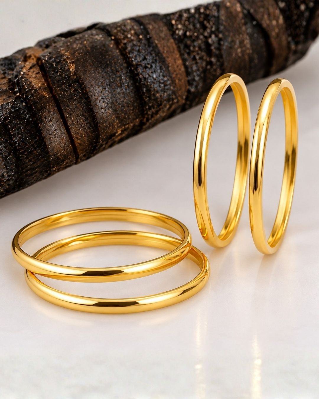 Four slim gold-plated rings stacked together Classic gold plated bangles with intricate engraved detailing for a timeless traditional look.