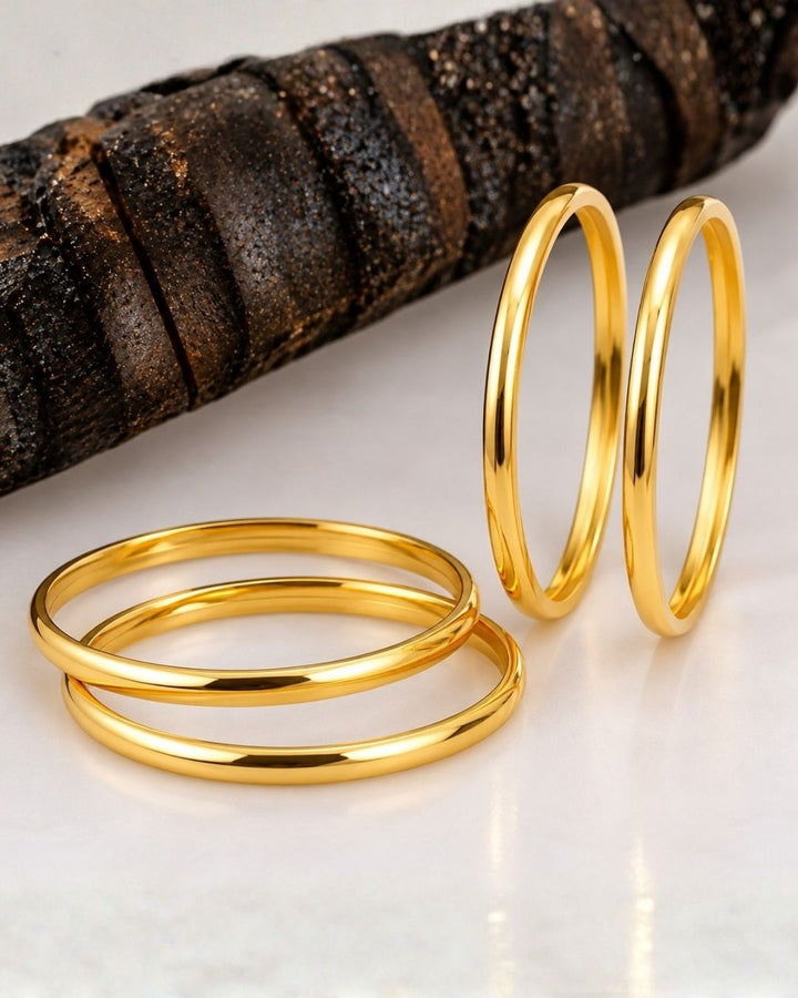 Four slim gold-plated rings stacked together Classic gold plated bangles with intricate engraved detailing for a timeless traditional look.