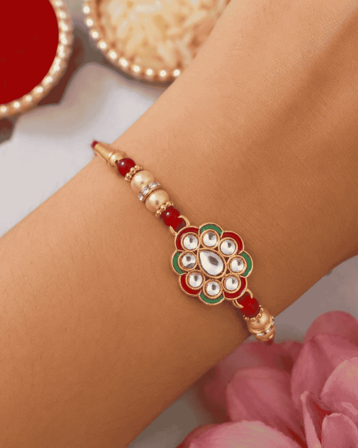 Elegant Floral Stone Rakhi showcasing a sparkling floral centerpiece with premium stone embellishments, golden beads, and a festive handcrafted design.
