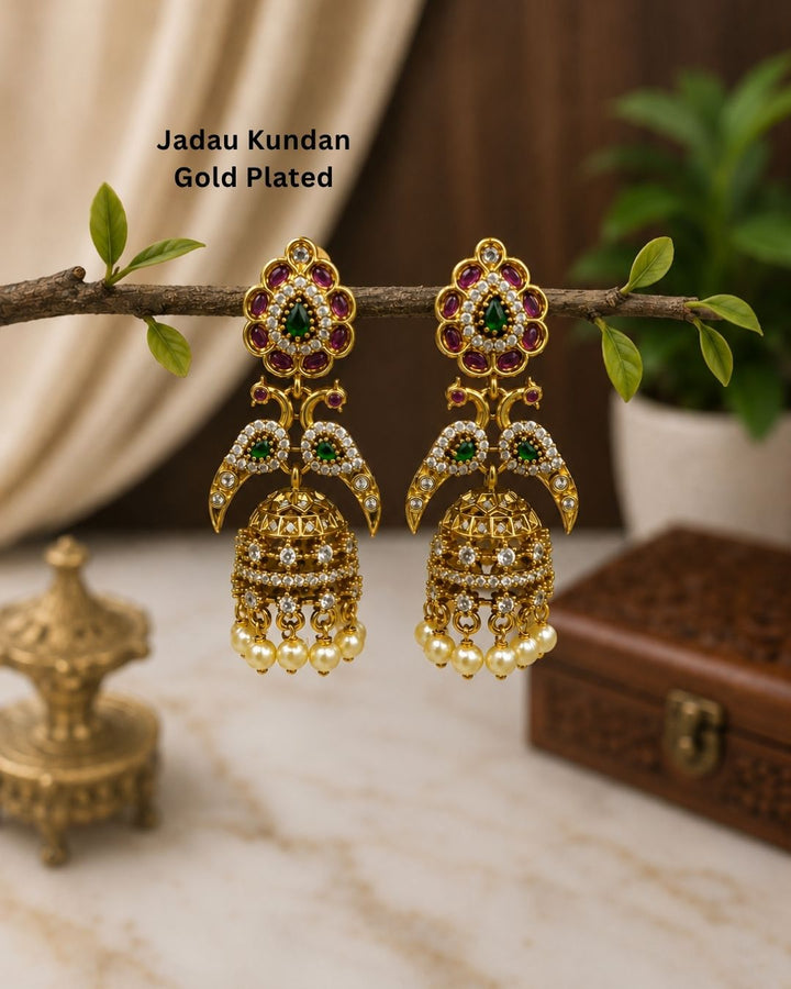Designer Gold Plated Jhumka Earrings with intricate Jadau Kundan craftsmanship, emerald-inspired stones, ruby-inspired accents, crystal detailing, and pearl drops.