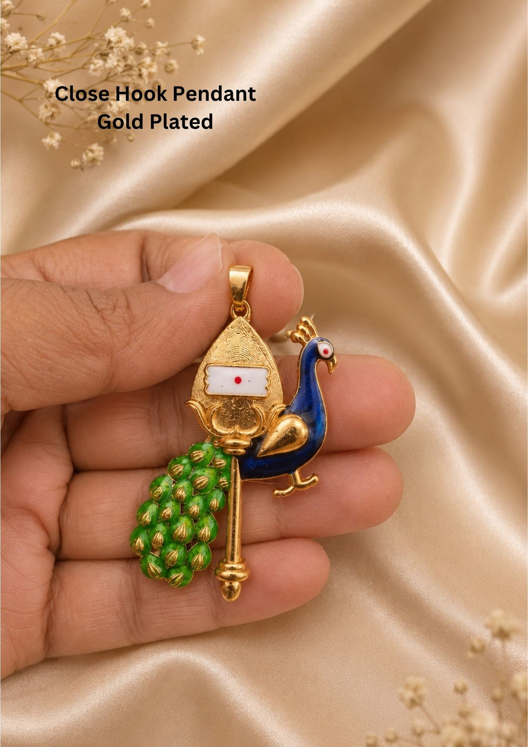 Gold plated religious pendant featuring a traditional golden Vel symbol decorated with a white and red pattern. A detailed side peacock figurine stands next to the spear, filled with shiny blue enamel on its body and bright green enamel work on its long layered tail feathers, providing a clean classic look suitable for daily wear, festivals, and spiritual occasions.