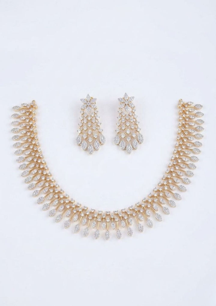 Elegant zircon diamond gold plated necklace set featuring a graceful collar-style necklace adorned with sparkling white zircon stones and cascading leaf-shaped dangling motifs. The matching statement earrings showcase a floral-inspired top with intricate stone-studded lattice detailing and shimmering leaf drops, creating a luxurious and sophisticated look suitable for weddings, receptions, parties and festive occasions.