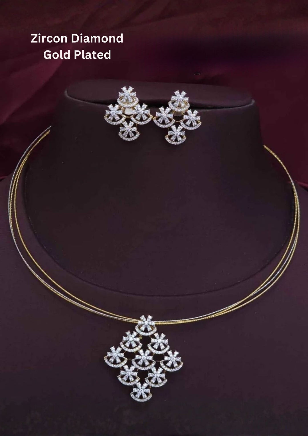 An elegant 18K gold-plated pendant set displayed on a dark brown mannequin stand, featuring a distinctive multi-layer thin wire chain. The main pendant showcases a geometric, diamond-shaped layout composed of intricate floral clusters and arches encrusted with pure white zirconian diamonds. The matching stud earrings perfectly mirror the same multi-star geometric pattern, creating a highly brilliant and contemporary festive look.