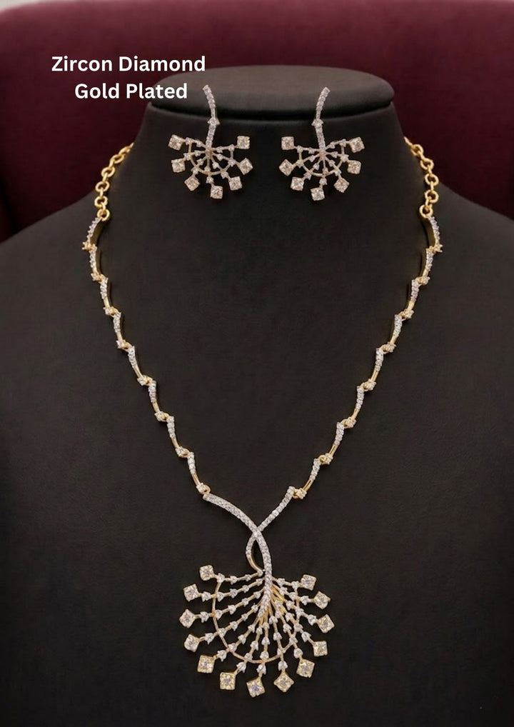 Elegant zircon diamond gold plated necklace set featuring a long designer chain with sparkling zircon stone links and a large fan shaped statement pendant decorated with square cut dangling zircon accents. The matching earrings have a stylish geometric floral pattern with shimmering diamond look stones, creating a luxurious modern ethnic appearance suitable for weddings, receptions, parties and festive occasions.