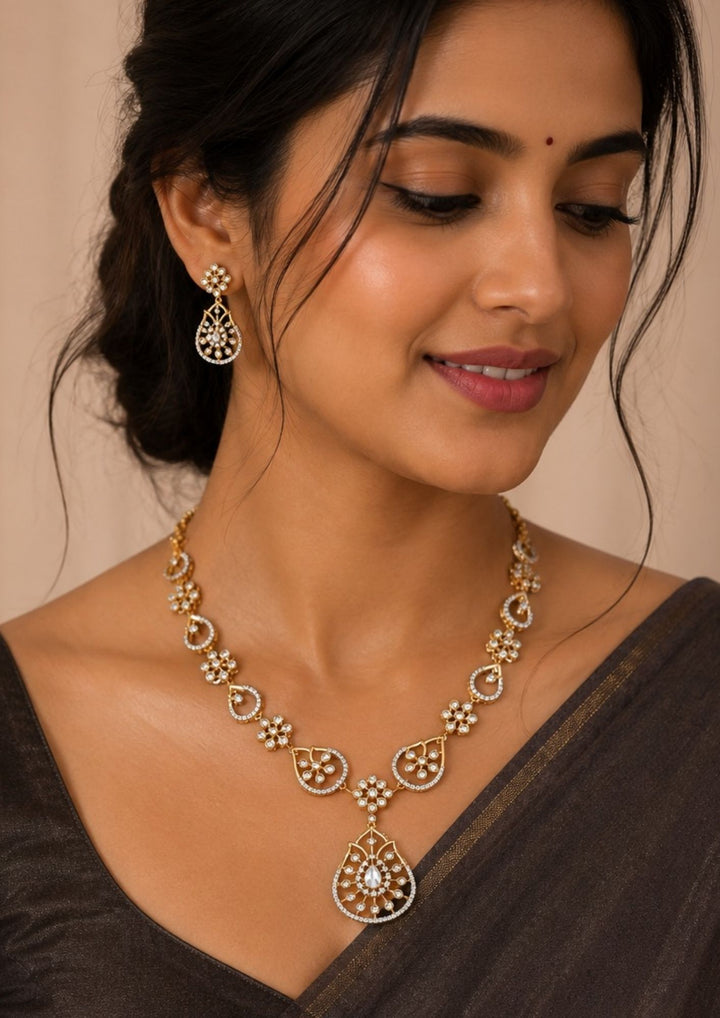 South Indian Women wearing Premium gold plated pendant necklace set crafted with shimmering zircon stones, floral detailing, and matching earrings for bridal, festive, and party wear jewellery collections.