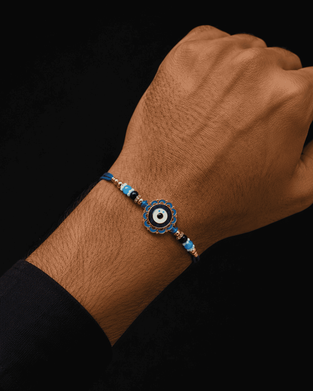 Elegant Evil Eye Rakhi with a blue enamel charm, gold-tone accents, and blue bead detailing, designed for stylish Raksha Bandhan celebrations.