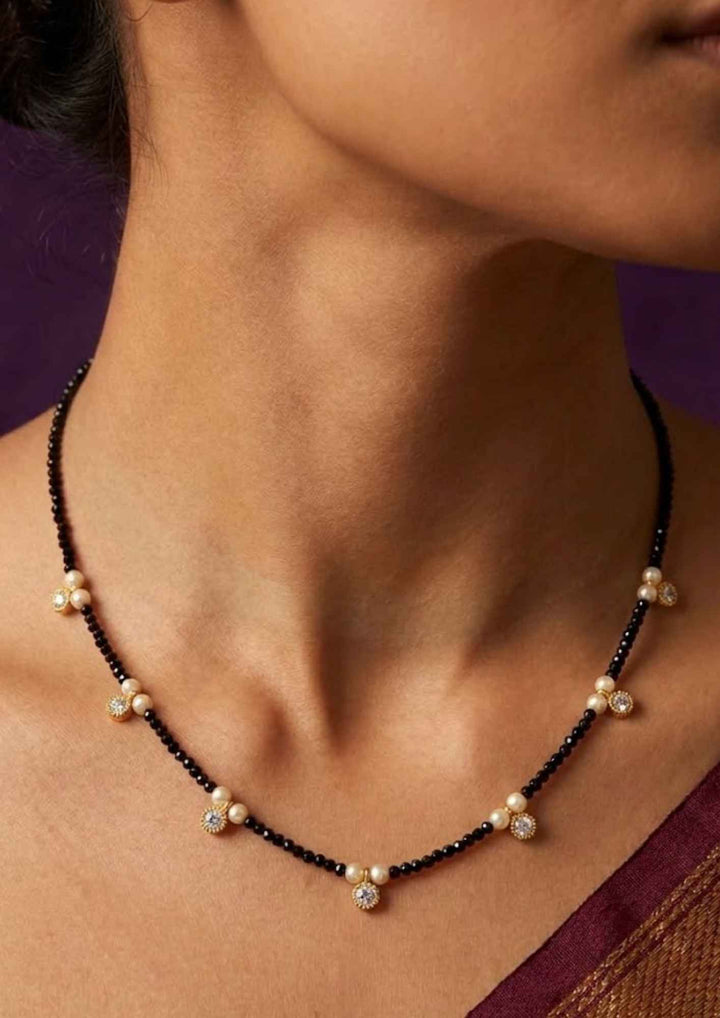Close-up of a pure Zirconian diamond 18k gold plated black bead necklace showing delicate pearl trio station charms that give a graceful traditional and modern look for daily office wear and casual gifting with COD.
