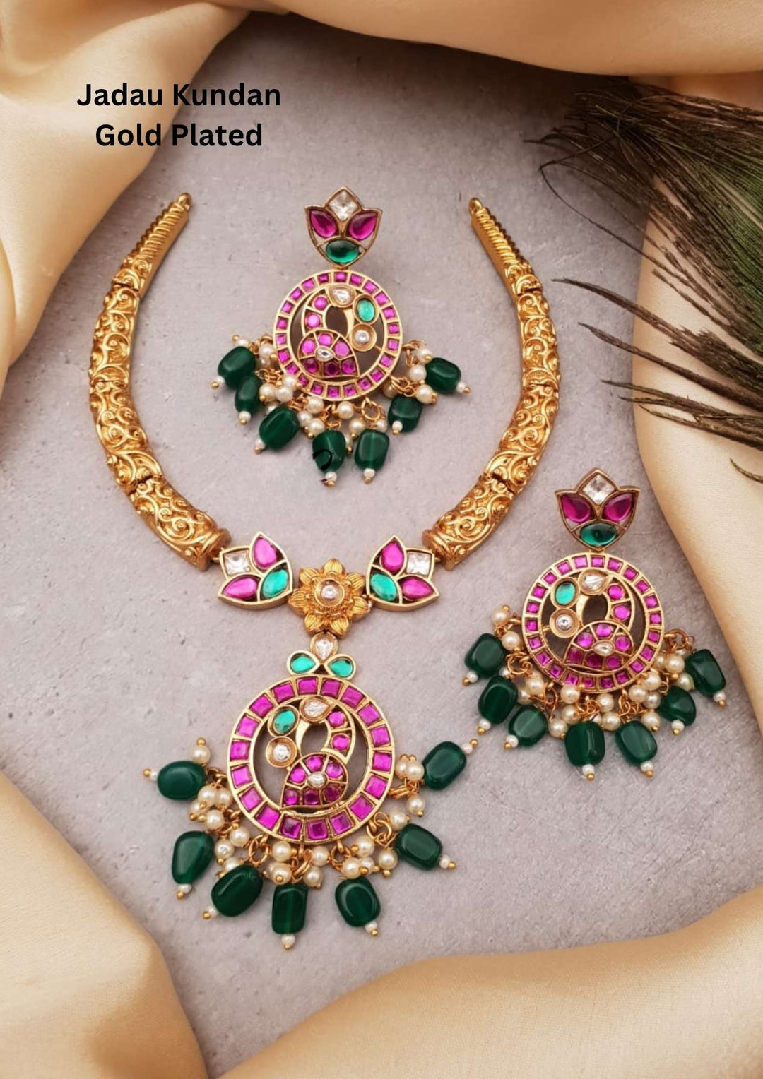 It is a real kempu Jadau kundan gold plated necklace set with matching earrings designed with pink kundan stones, green bead drops, white stones, pearl hangings, antique carved gold finish, circular peacock-inspired pendant design, suitable for weddings, festive occasions, temple wear, bridal styling, and traditional South Indian outfits with elegant royal appearance.