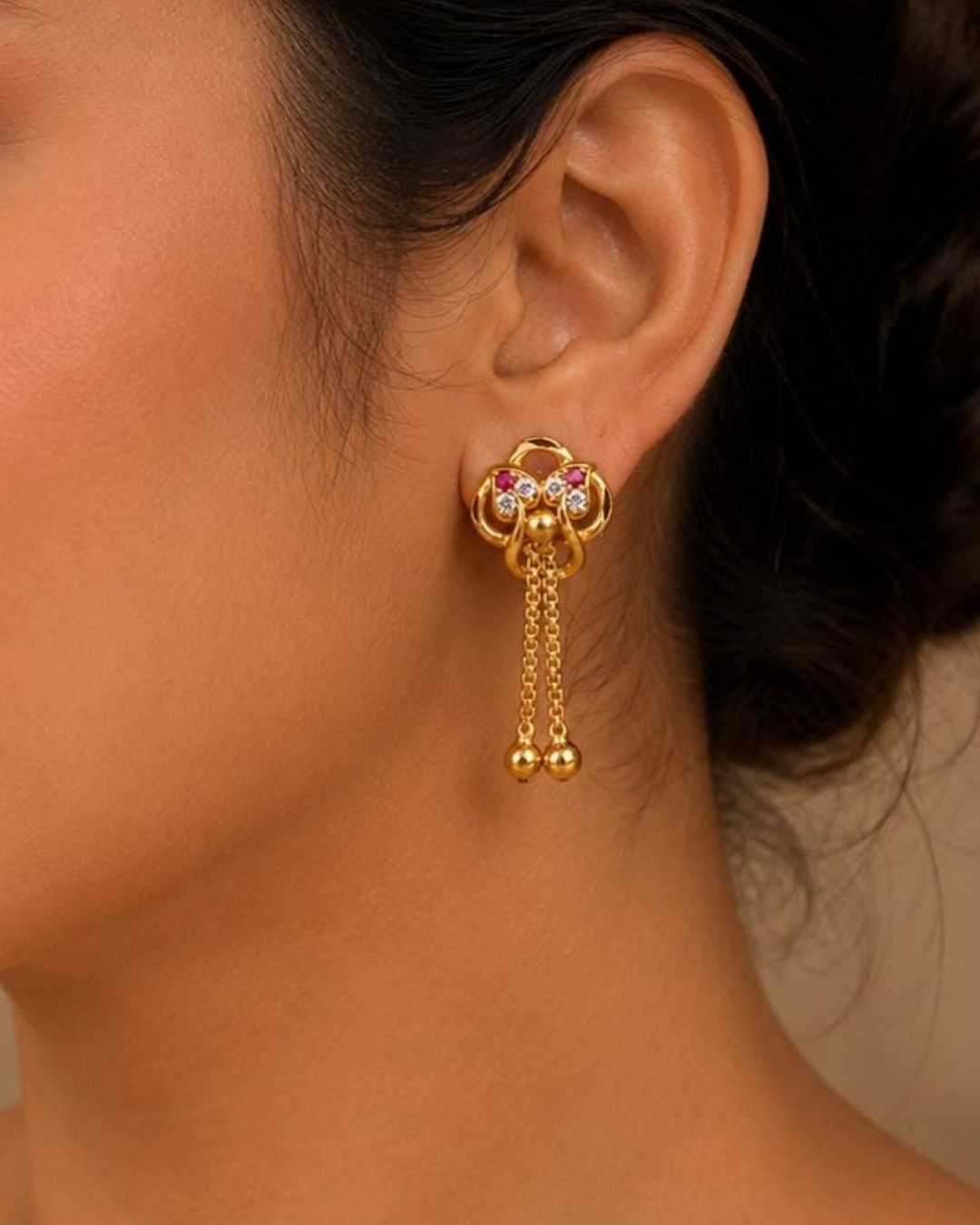 Shop Gold Plated Designer Long Drop Earrings featuring ruby and white stone detailing, intricate gold motifs, elegant chain drops, and polished gold ball accents. Perfect for festive and traditional occasions. COD available at Zevana.