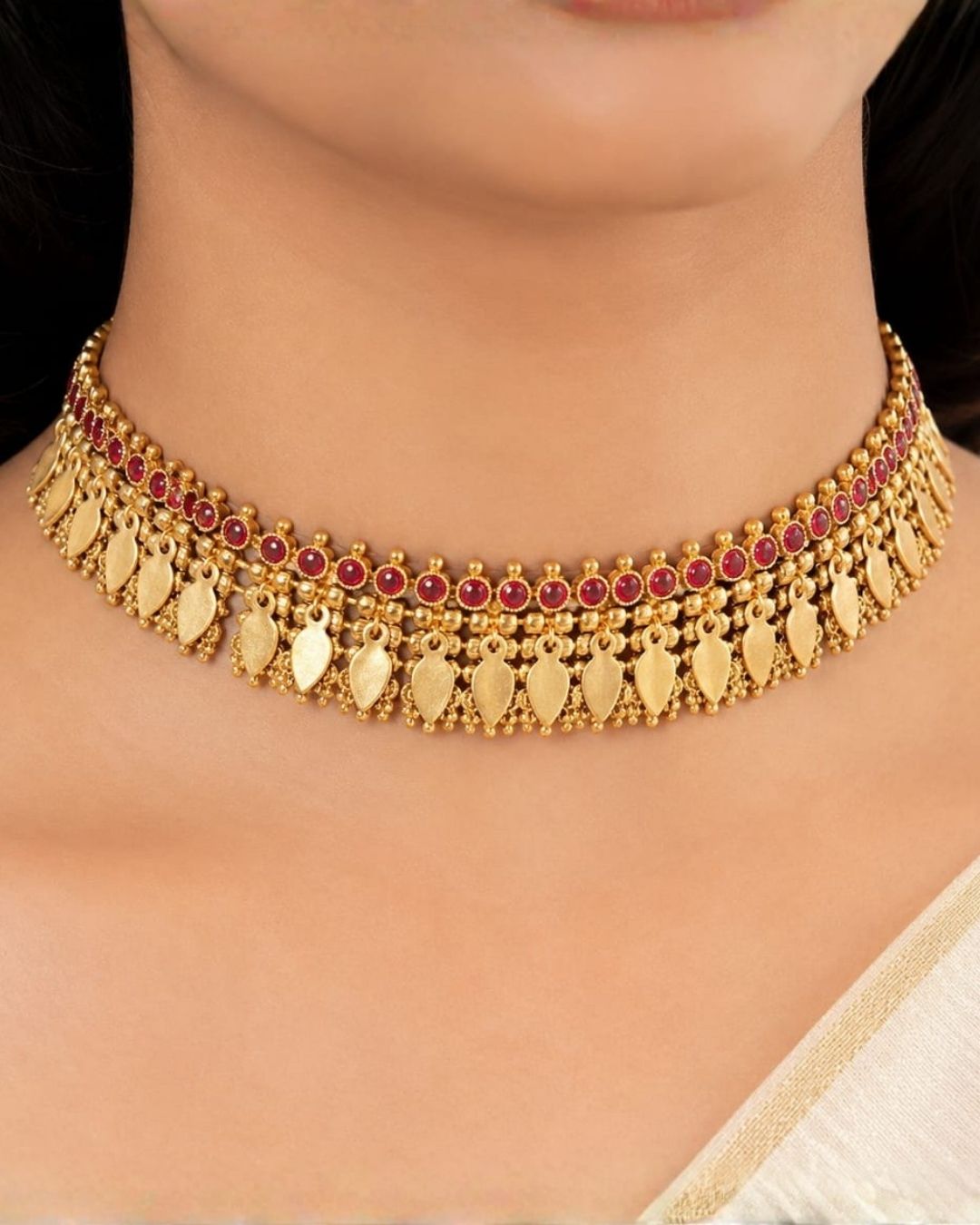 South indian women Beautiful gold plated Kundan choker necklace set featuring a detailed ruby stone border, layered golden beadwork, and elegant hanging motifs, paired with matching earrings. Perfect for festive occasions, traditional wear, weddings, and gifting.