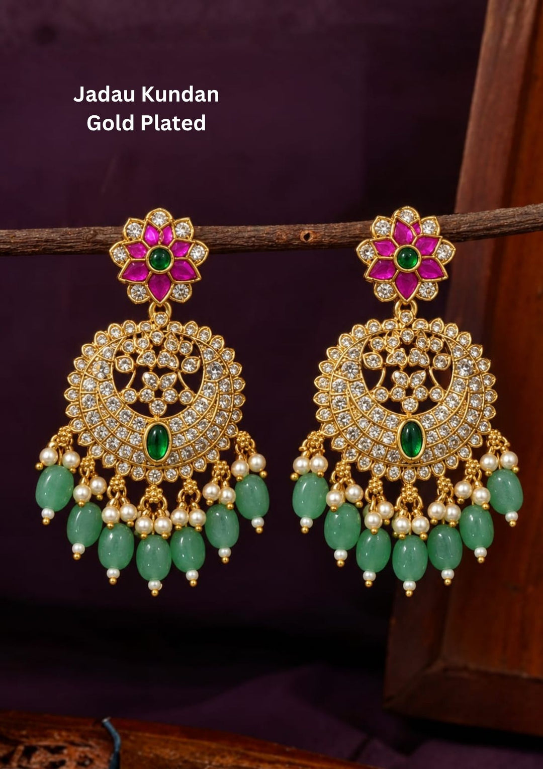 Beautiful Jadau Kundan gold plated Chandbali earrings featuring ruby pink floral motifs, sparkling white kundan stones, green stone accents, pearl detailing, and green bead drops. Perfect for weddings, festivals, temple visits, traditional outfits, bridal wear, and premium gifting.