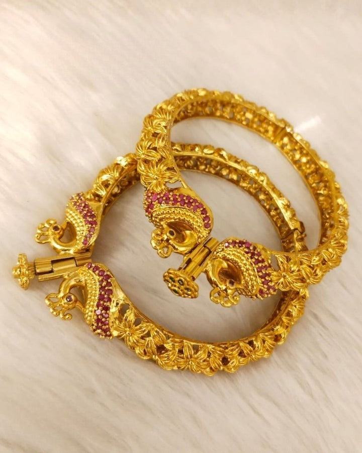Designer Openable Peacock Gold Plated Kankanalu with floral engraved detailing, ruby-inspired embellishments, intricate craftsmanship, and an elegant hinged design.