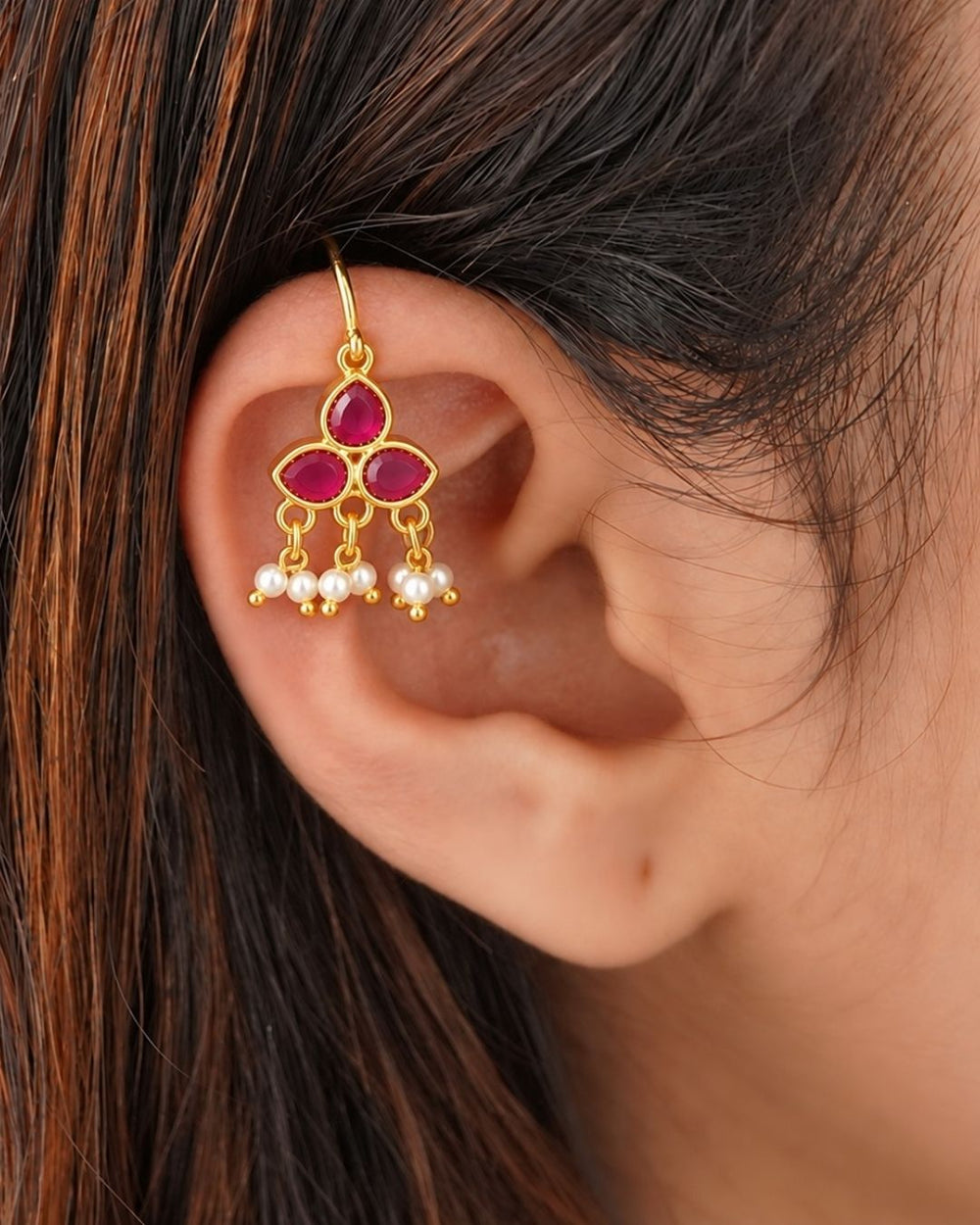 Premium gold plated bugadi earrings featuring a stylish three-stone floral design with rich ruby-colored stones and delicate hanging pearl clusters. Perfect for traditional wear, weddings, festive occasions, parties, and gifting.