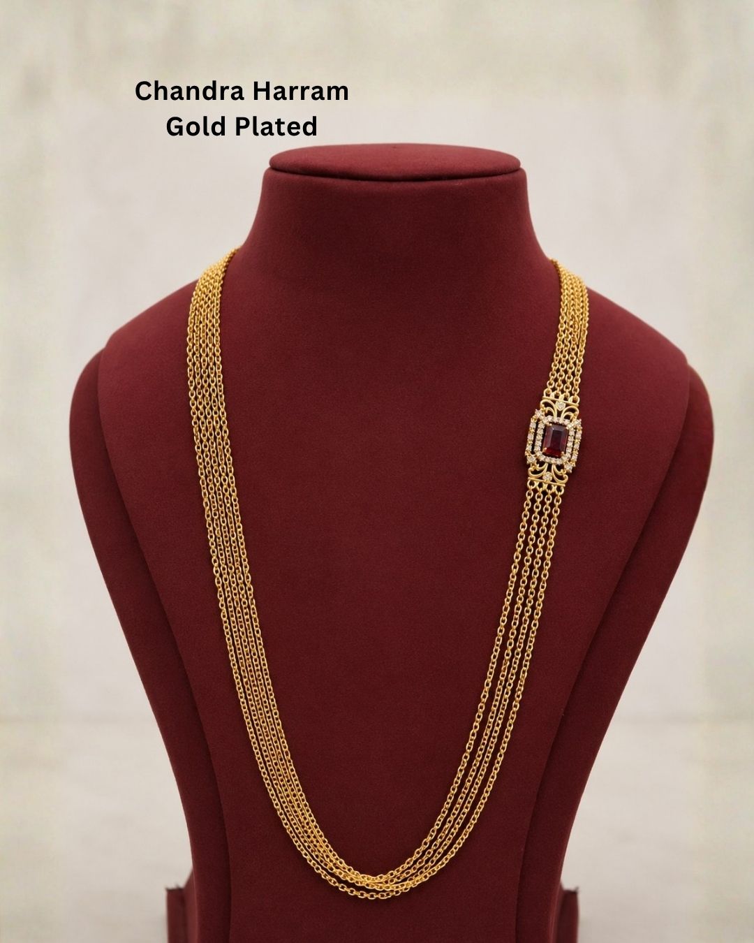 Beautiful multi-layer Chandra Haram gold plated necklace featuring a striking ruby-colored centerpiece with intricate detailing and sparkling accents. Perfect for festive occasions, traditional outfits, weddings, temple visits, and premium gifting.