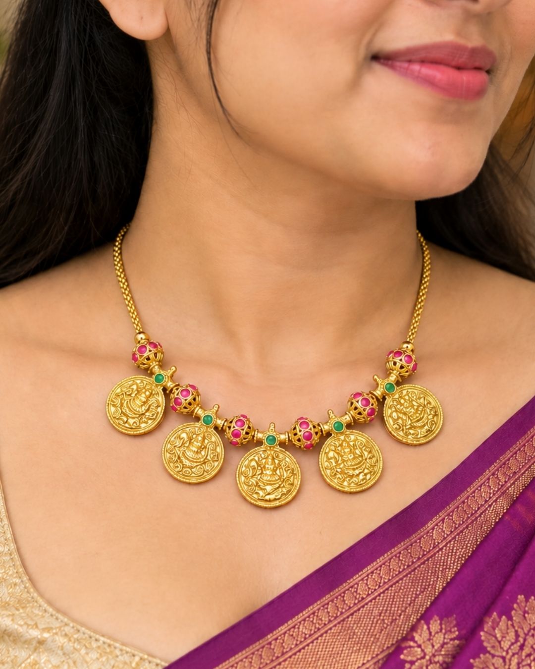 Traditional gold plated designer necklace and earrings set featuring multiple Goddess Lakshmi coin pendants, intricate temple-inspired detailing, ruby and green stone accents, and matching Lakshmi coin earrings, perfect for festive, wedding, and traditional occasions.