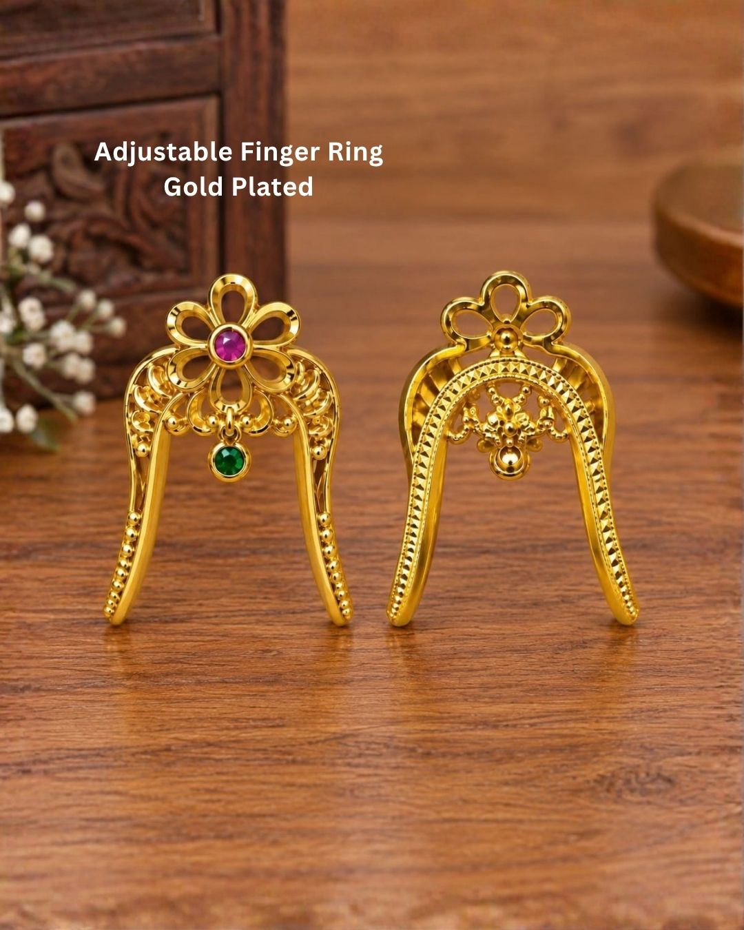 Traditional gold plated floral hair pin featuring an intricate openwork design, ruby and green stone embellishments, and curved prongs for securing the hairstyle.