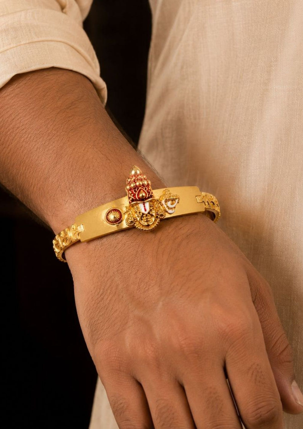 AClose-Up of a South Indian man styling a gold plated Balaji design bracelet with traditional and ethnic outfits. The bracelet features temple-inspired craftsmanship, embossed detailing and an adjustable secure clasp that adds a bold and devotional touch to festive and everyday styling.