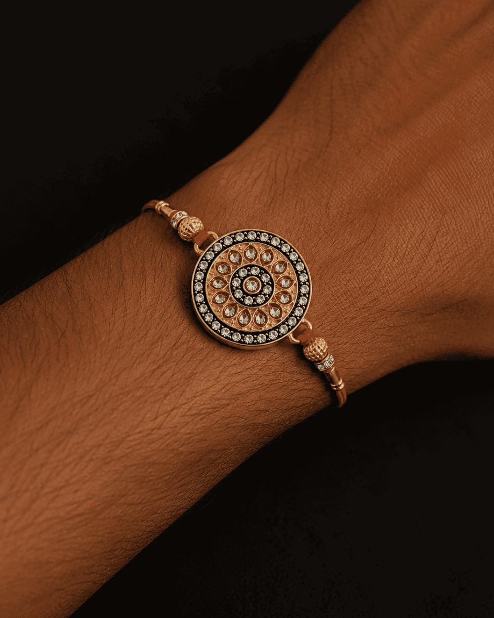 Beautiful Royal Designer gold plated Rakhi featuring a stone-studded circular centerpiece and elegant bead detailing. Perfect for Raksha Bandhan celebrations and thoughtful gifting.