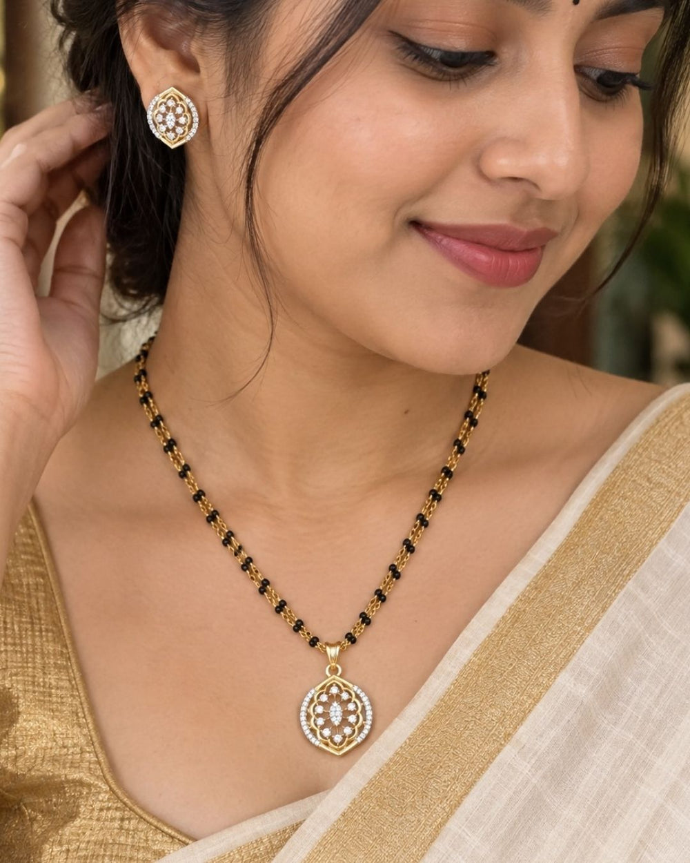 Elegant gold plated mangalsutra set with zircon diamond pendant, matching earrings and premium black bead chain.erfect for everyday elegance.