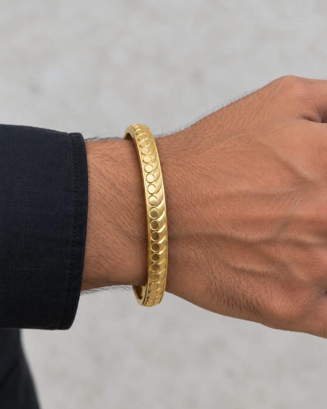 Elegant gold plated men’s kada featuring a bold circular and curved pattern design with a smooth polished finish, suitable for traditional and modern wear.