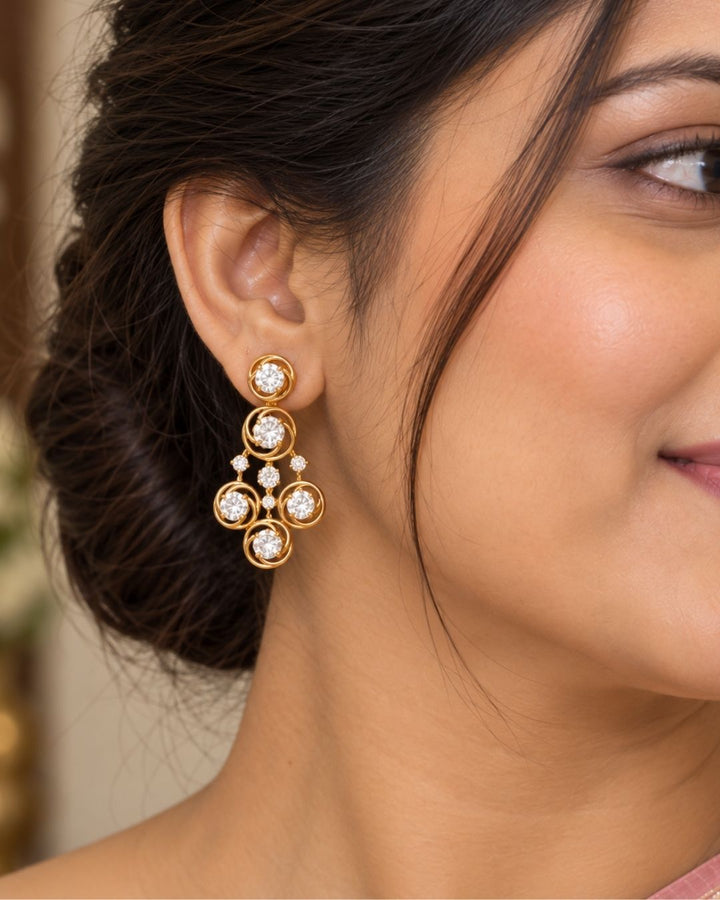 Gold plated two-layer necklace and matching hanging earrings set featuring two lines of small, round white stones. The chains join at a central round flower motif, from which three delicate lines of white stones hang down, each ending in a small circle design. The set features a clean layout suitable for festivals, family parties, and traditional celebrations.
